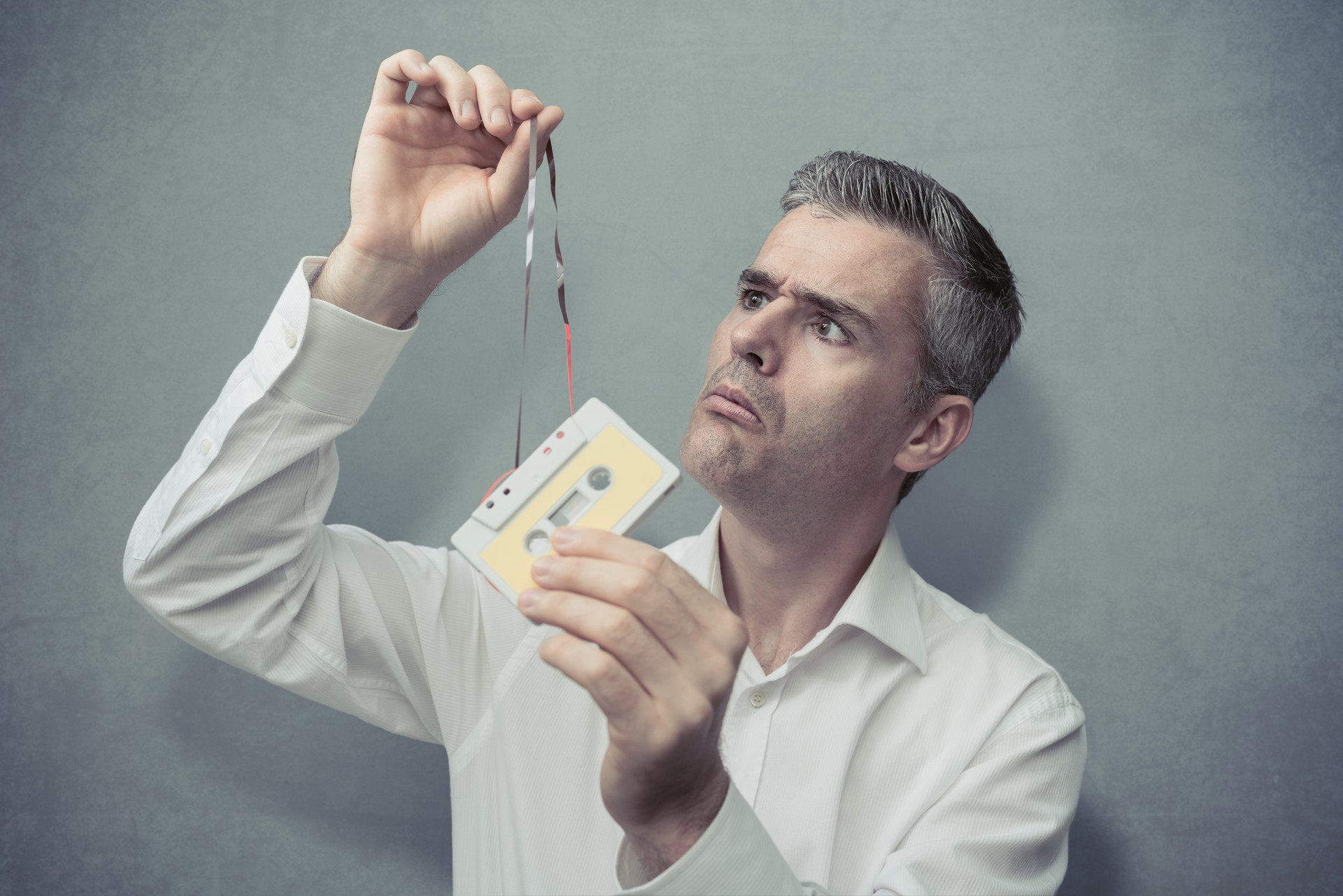 Clueless man holding an audio cassette