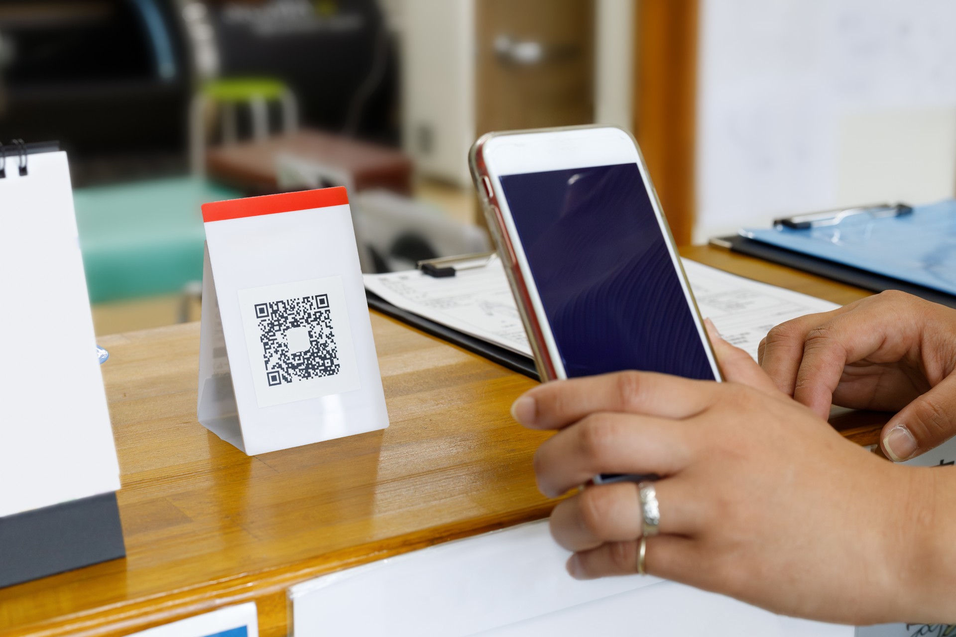 Cashless payment at hospitals and clinics. A woman reading a QR code with her phone.