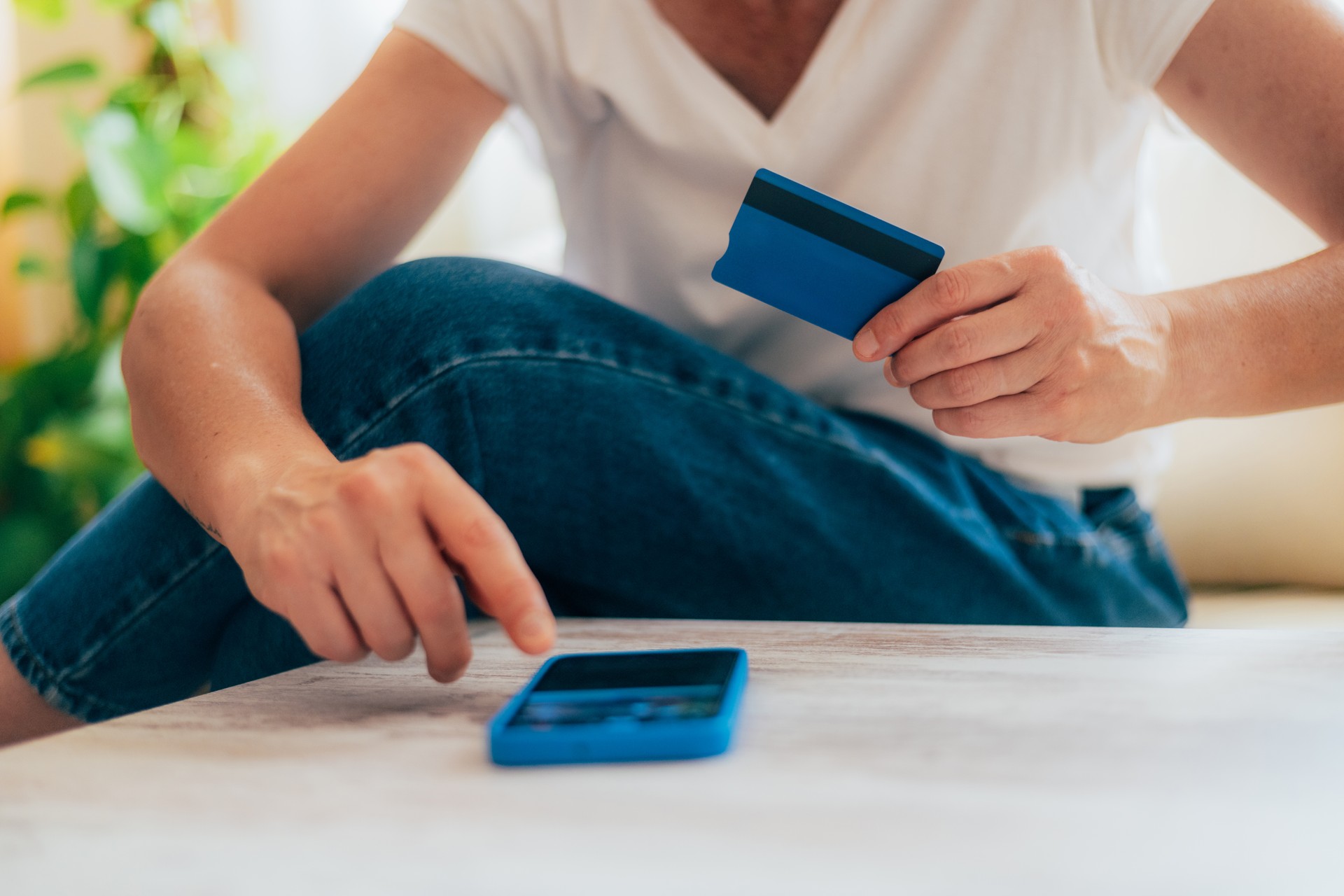 Reliable Online Transaction With Credit Card And Phone. Woman On Couch, Using Credit Card And Smartphone For Payment Or Banking Online. Safe E-Shopping